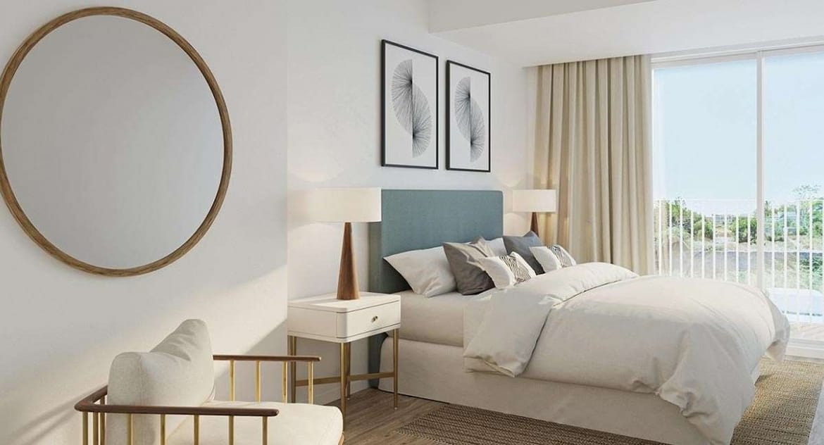 Rendering of a double bedroom with a timber armchair, round mirror and glazed doors in Jávea, Alicante