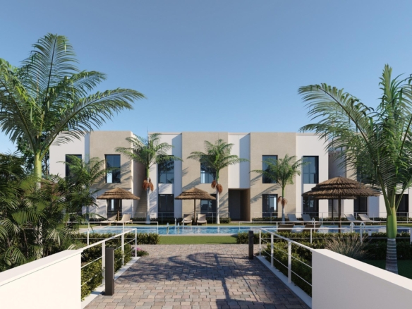 Modern low-rise apartments with central swimming pool, sunbeds and palm trees in foreground