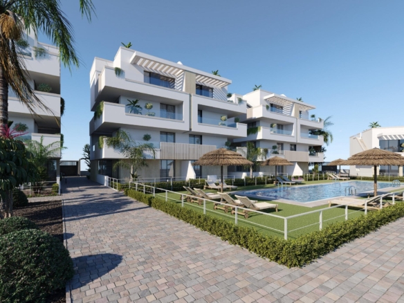 Modern white apartment block beside communal pool with straw parasols and sun loungers