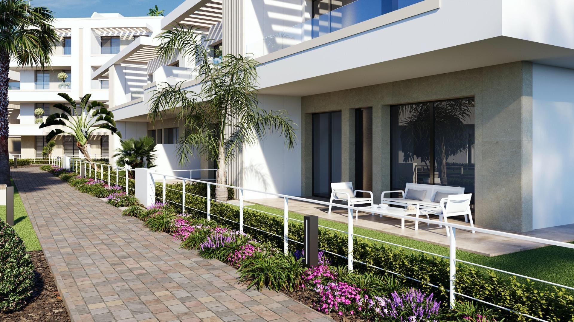 New-Build-Apartments-and-Bungalows-in-Santa-Rosalia-Lake-and-Life-Resort-3 Ground-floor terrace with outdoor seating beside a landscaped paved walkway