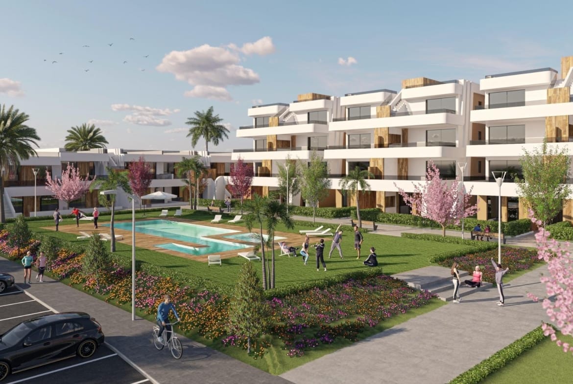 Communal swimming pool and gardens beside contemporary apartment buildings