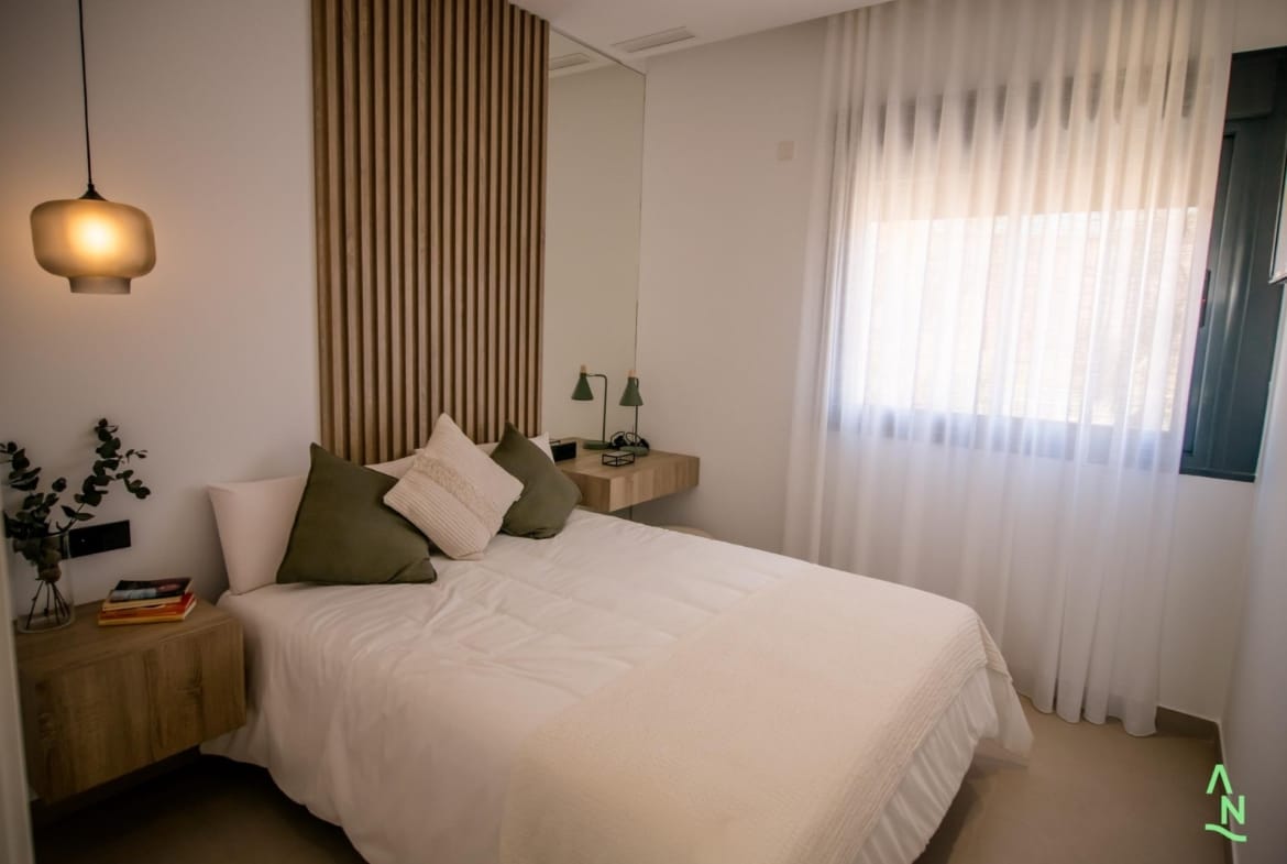 Comfortable bedroom with window and wood feature wall
