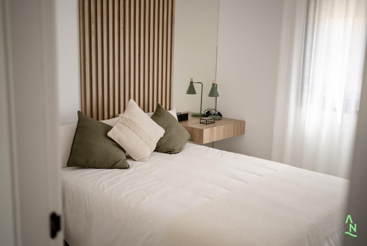 Bright second bedroom with double bed and bedside shelf