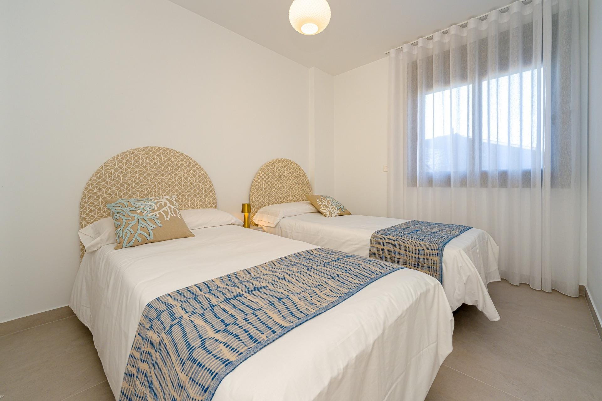 Twin bedroom with two single beds and a large window