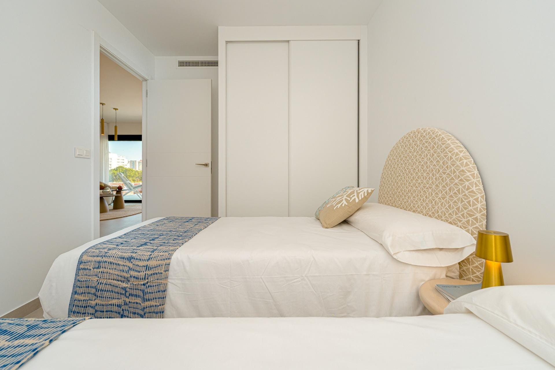 Twin bedroom with fitted wardrobe and doorway to the living area
