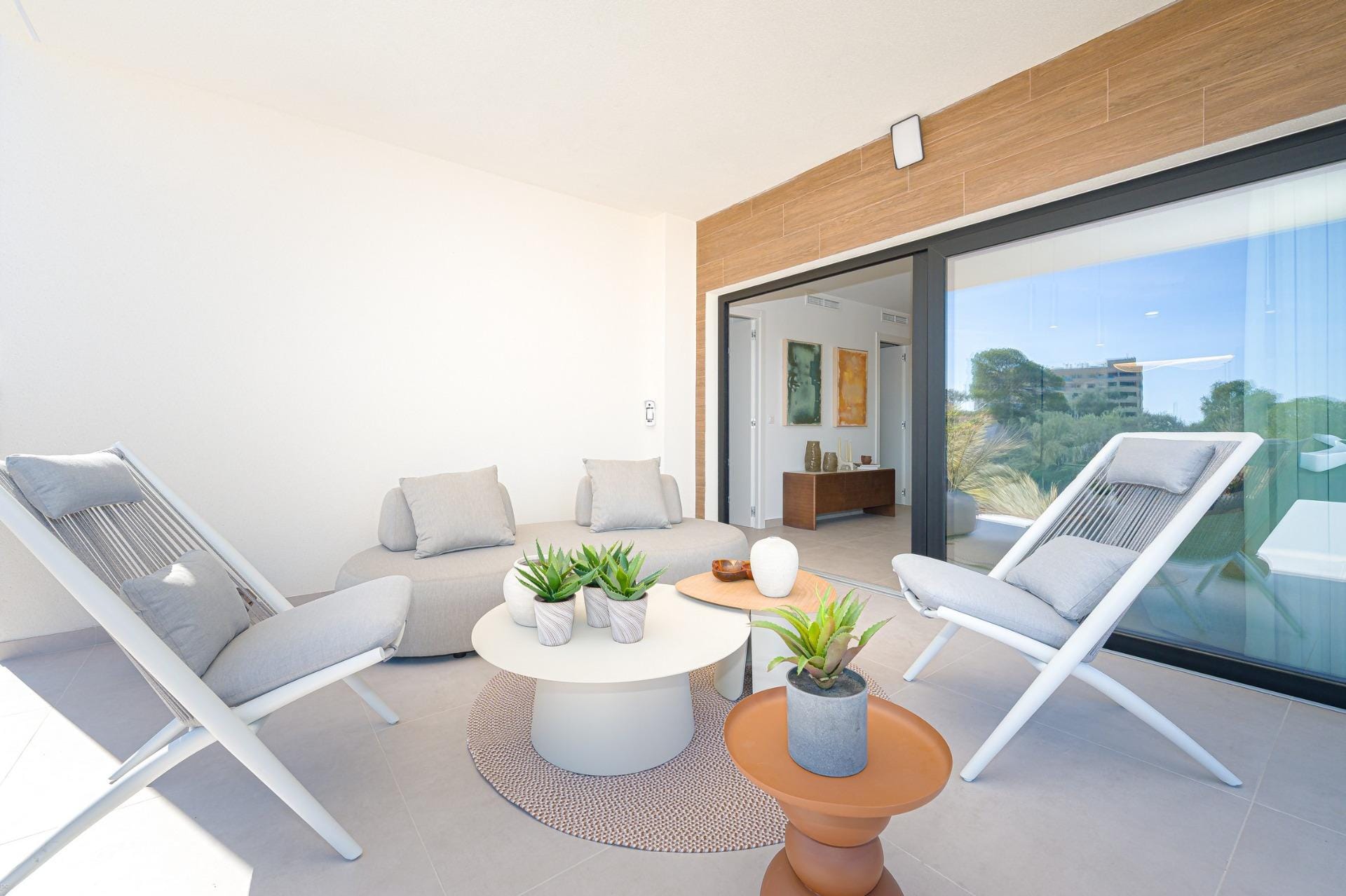 Spacious covered terrace with lounge chairs and coffee tables
