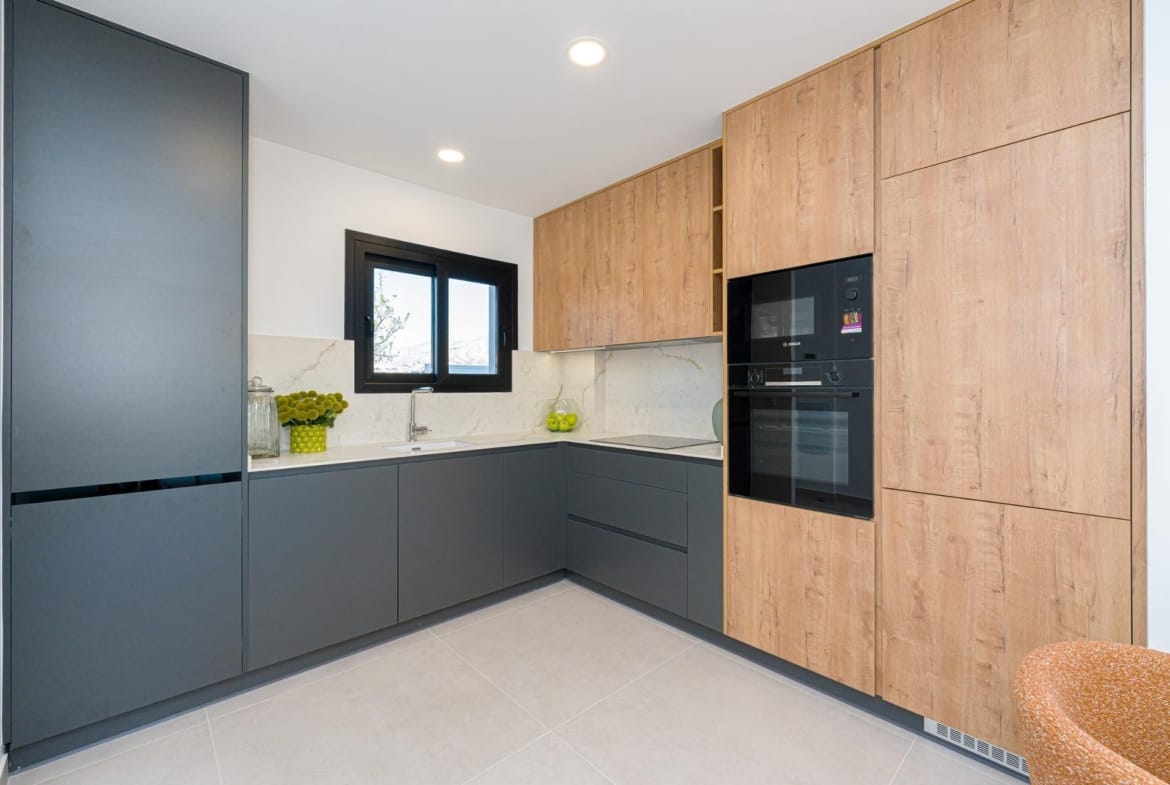 Modern L-shaped kitchen with integrated appliances and stone-look splashback