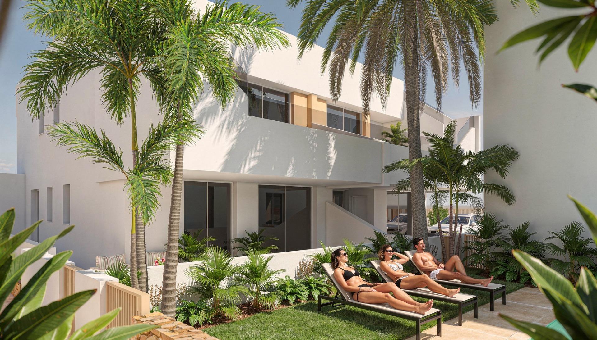Sunbathers on loungers beside planted terraces in front of a white, modern apartment façade