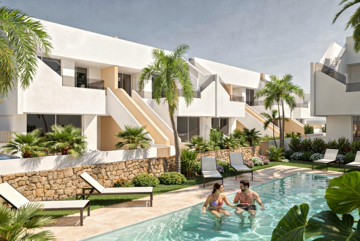 Communal pool area with loungers, couple in the water and white modern terraces