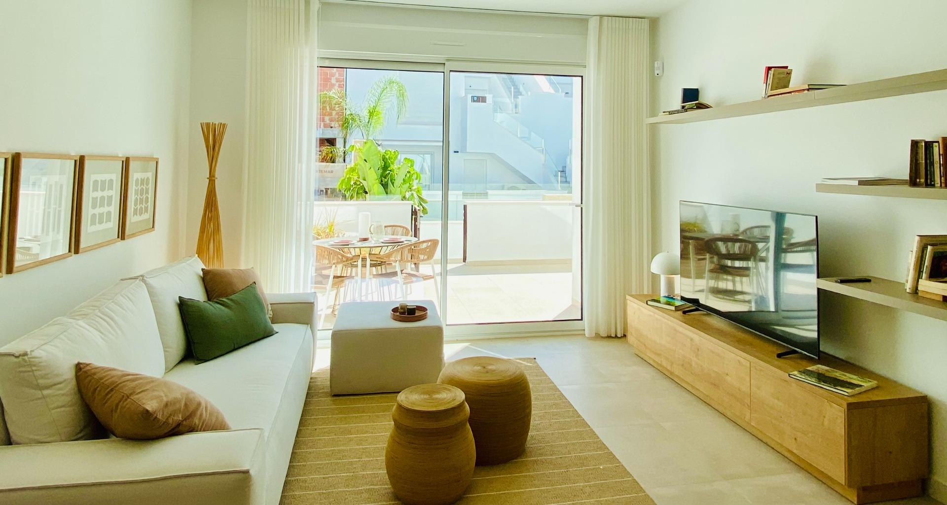 Living room viewed towards sliding doors opening to a sunny terrace and balcony
