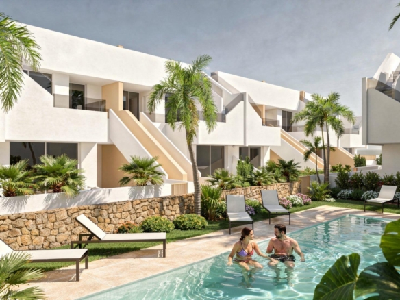 Couple in a communal pool in front of white modern penthouse apartments and sun loungers