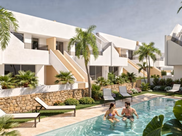 Couple in a communal pool in front of white modern penthouse apartments and sun loungers