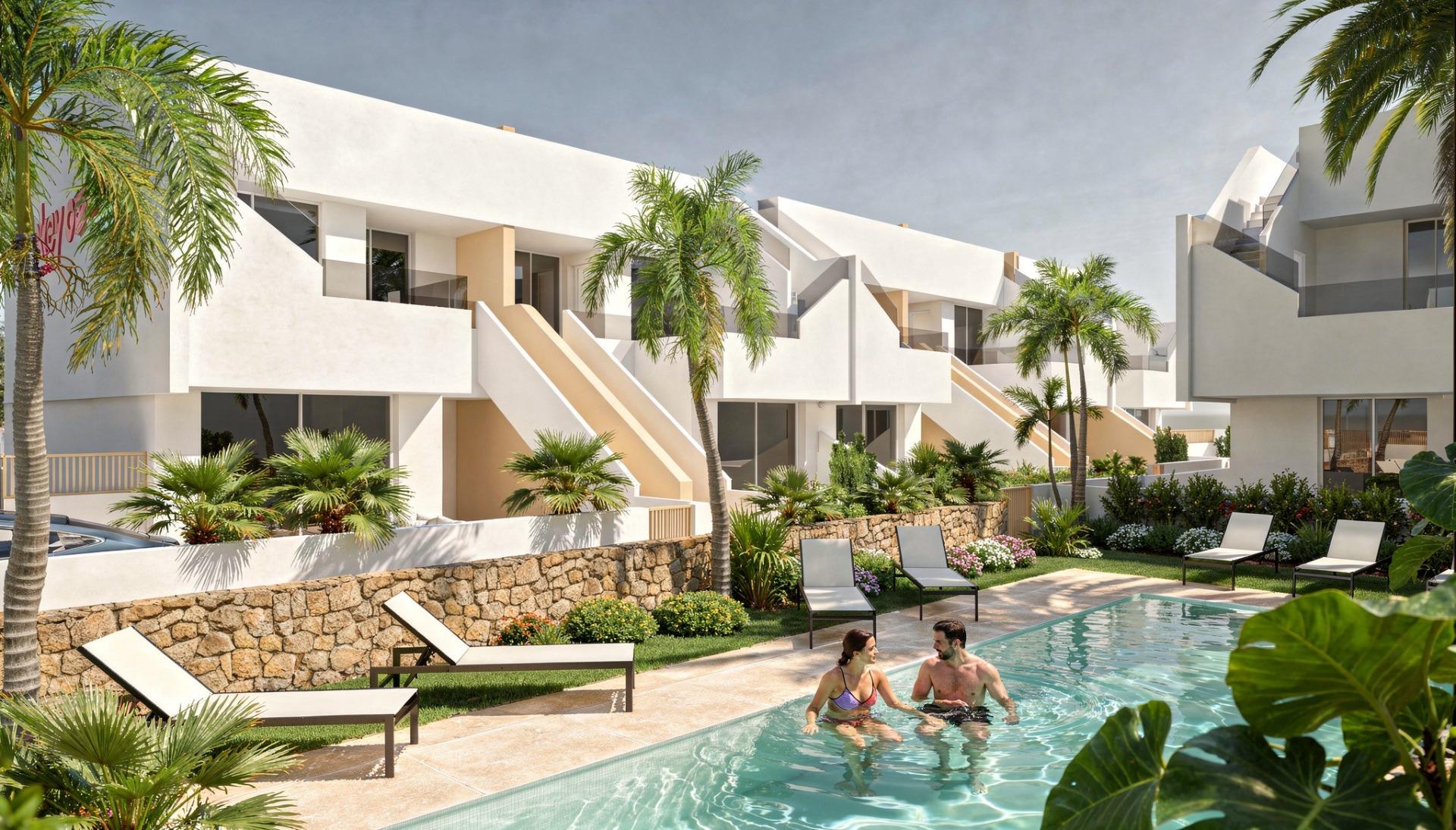 Couple in a communal pool in front of white modern penthouse apartments and sun loungers
