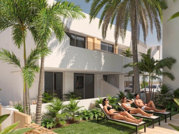 Ground-floor apartment exterior and landscaped terrace with sunloungers and palm trees