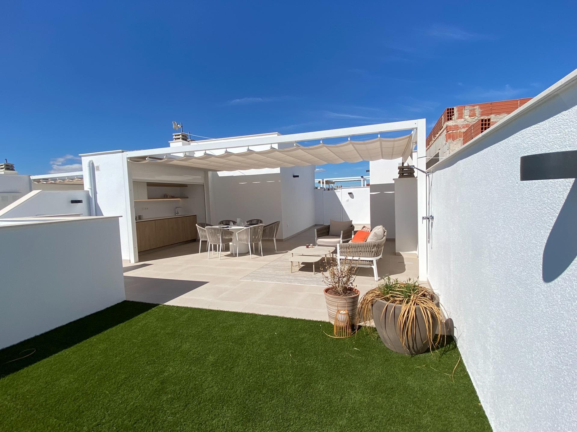 Spacious rooftop terrace with shaded pergola, dining set, lounge furniture and artificial grass