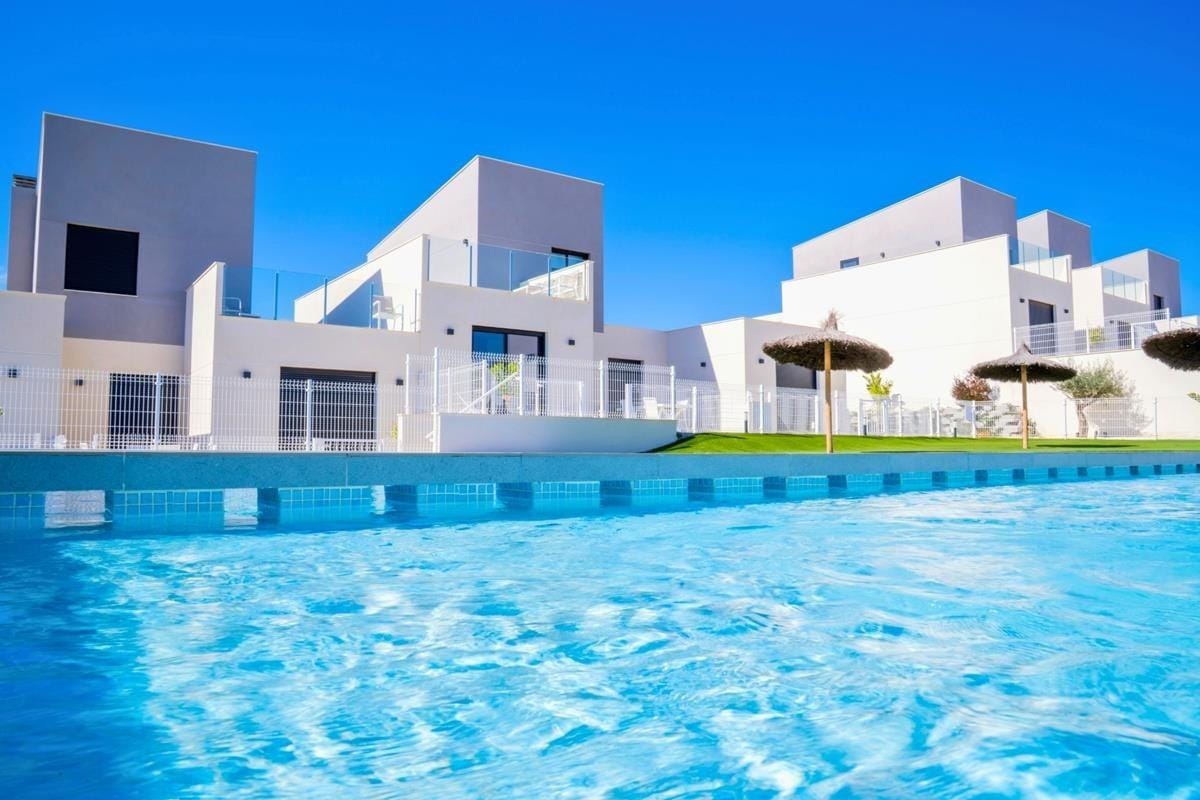 Communal swimming pool with contemporary white homes beyond in Altaona Golf, Baños y Mendigo, Murcia