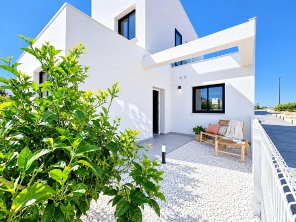 White homes beside a gravelled garden seating area and citrus tree in Altaona Golf, Baños y Mendigo, Murcia