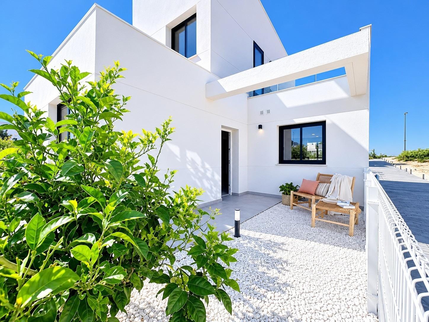 White homes beside a gravelled garden seating area and citrus tree in Altaona Golf, Baños y Mendigo, Murcia