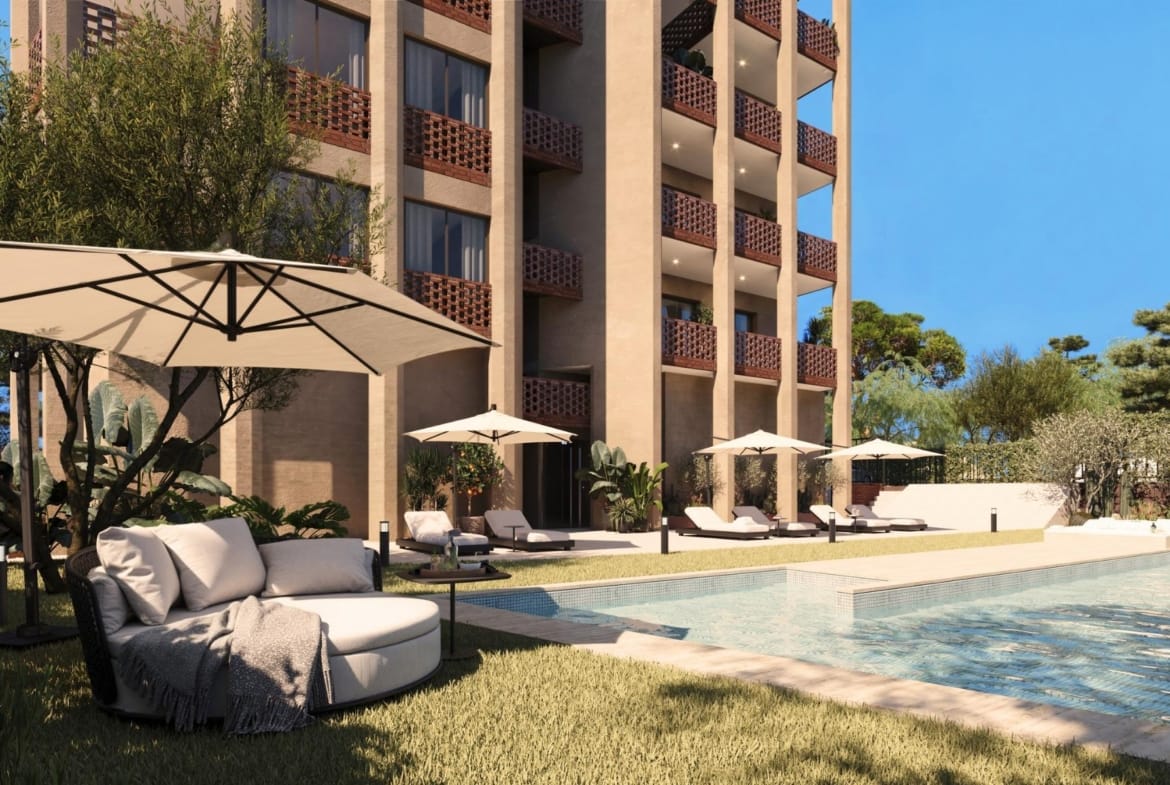 Communal pool area with sun loungers and landscaped garden beside the building