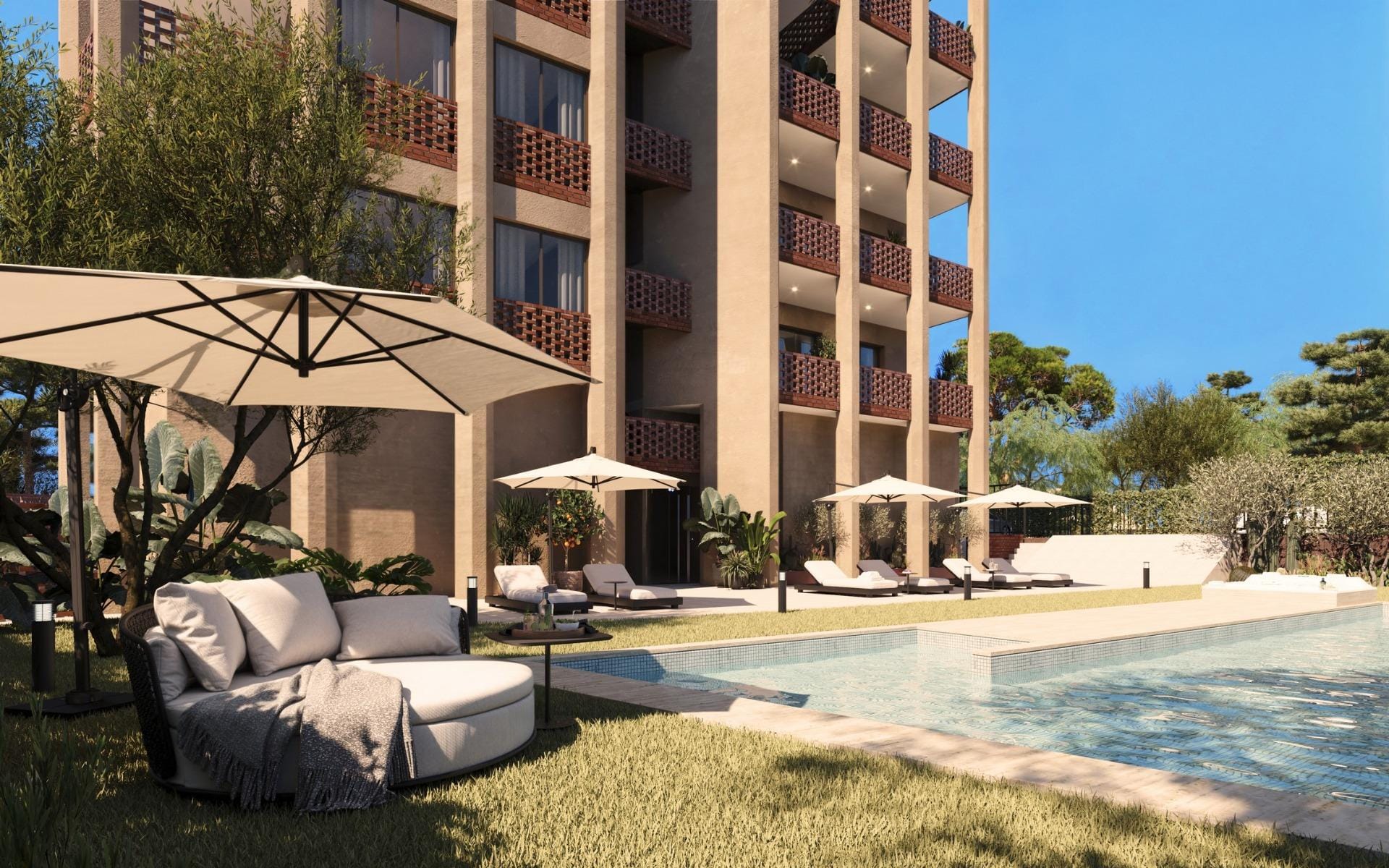 Communal pool area with sun loungers and landscaped garden beside the building
