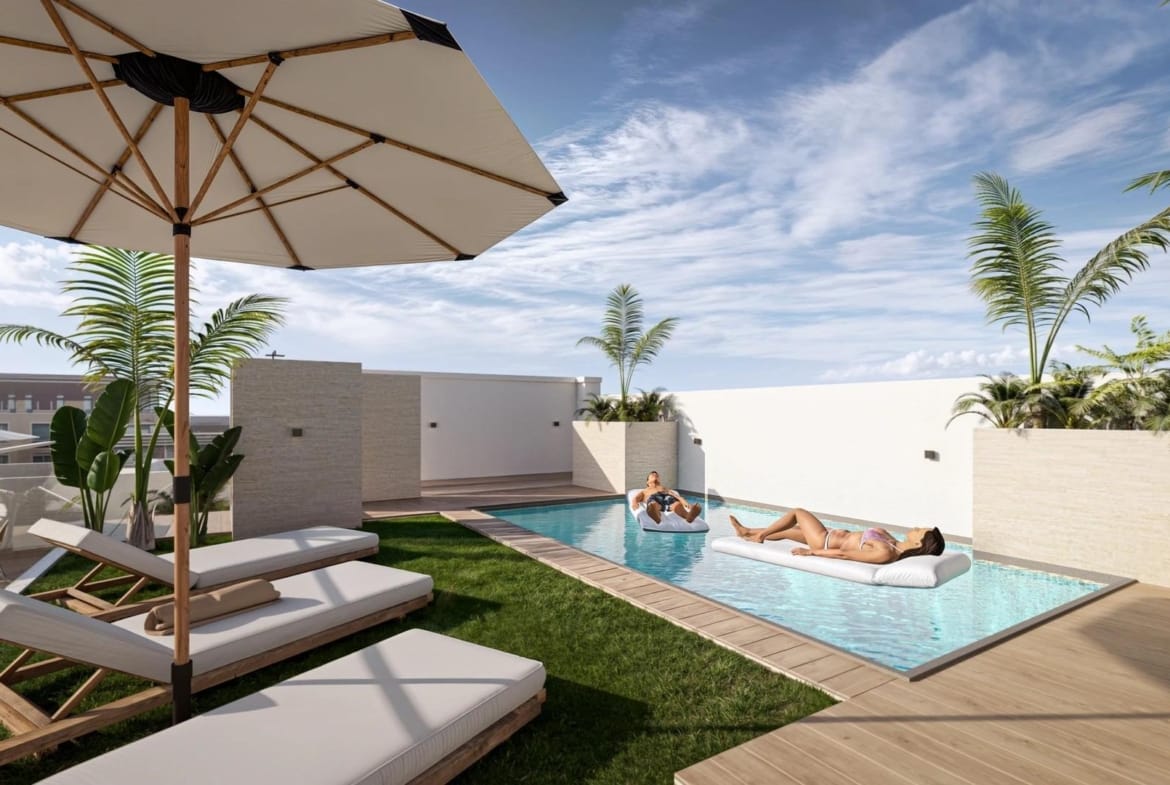 A communal rooftop pool with loungers and parasols in daylight in Torrevieja, Alicante