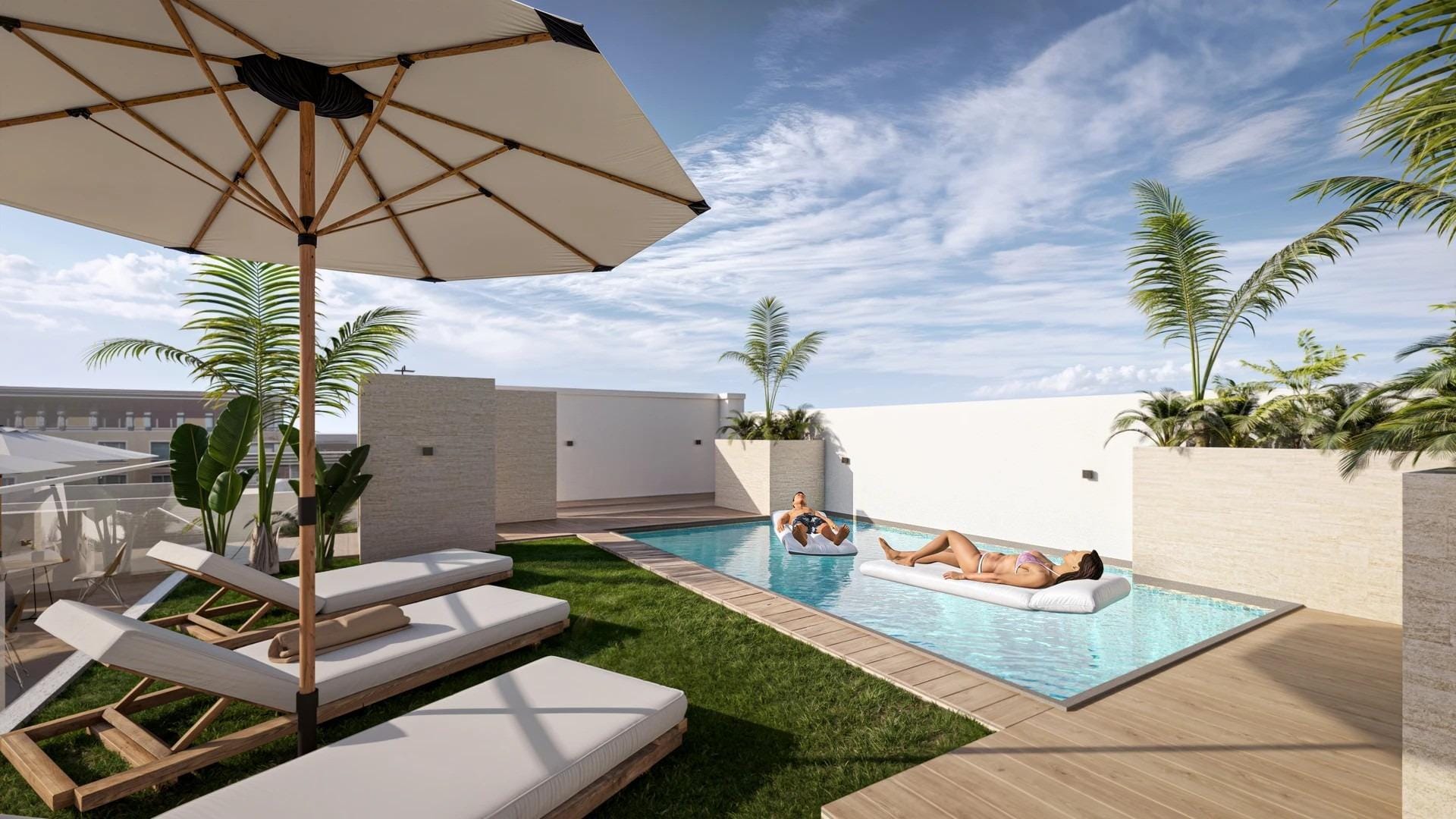 A communal rooftop pool with loungers and parasols in daylight in Torrevieja, Alicante