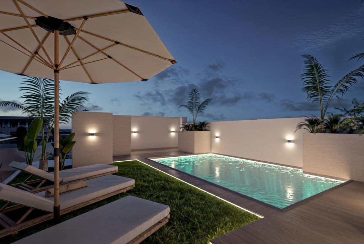 An illuminated communal rooftop pool at dusk in Torrevieja, Alicante