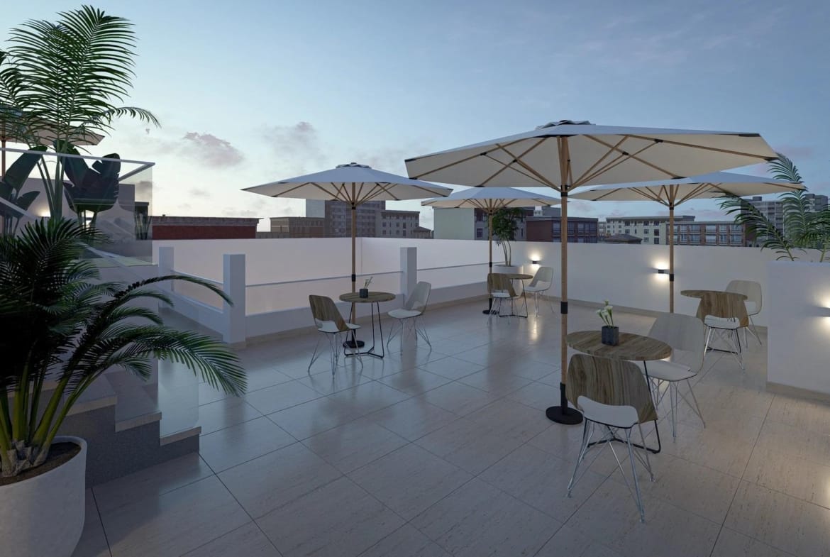 A shared rooftop seating area with parasols at dusk in Torrevieja, Alicante