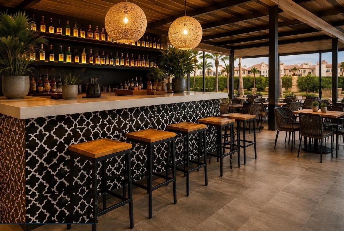 Indoor-outdoor bar area with tiled counter, wooden stools and dining tables