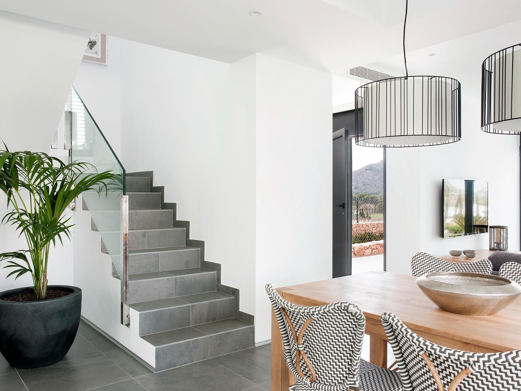 New-Build-Villas-for-Sale-at-La-Manga-Club-–-Luxury-Living-in-a-Prestigious-Resort-10 Dining area beside the staircase and large entrance glazing in La Manga Club, Murcia