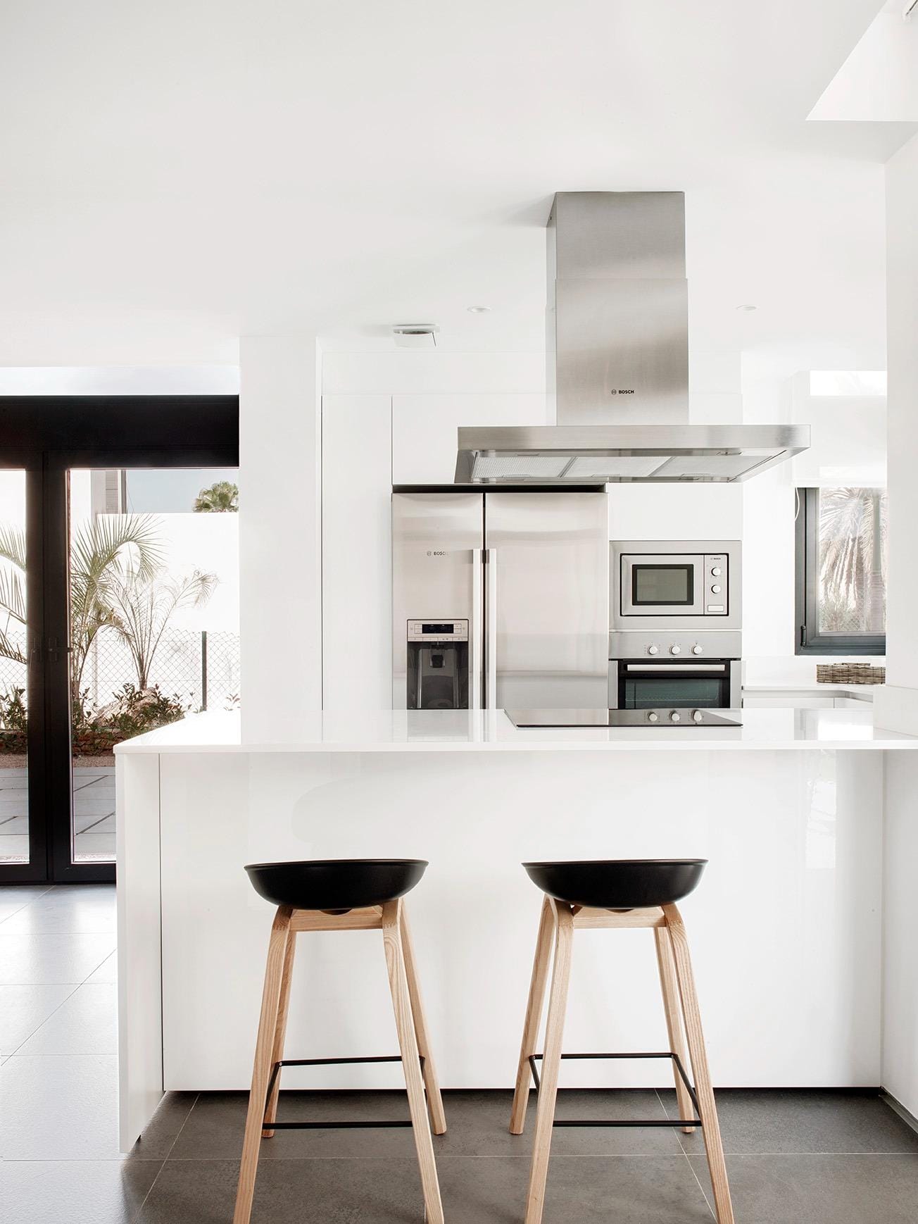 New-Build-Villas-for-Sale-at-La-Manga-Club-–-Luxury-Living-in-a-Prestigious-Resort-13 Kitchen island with breakfast stools and sleek fitted appliances in La Manga Club, Murcia