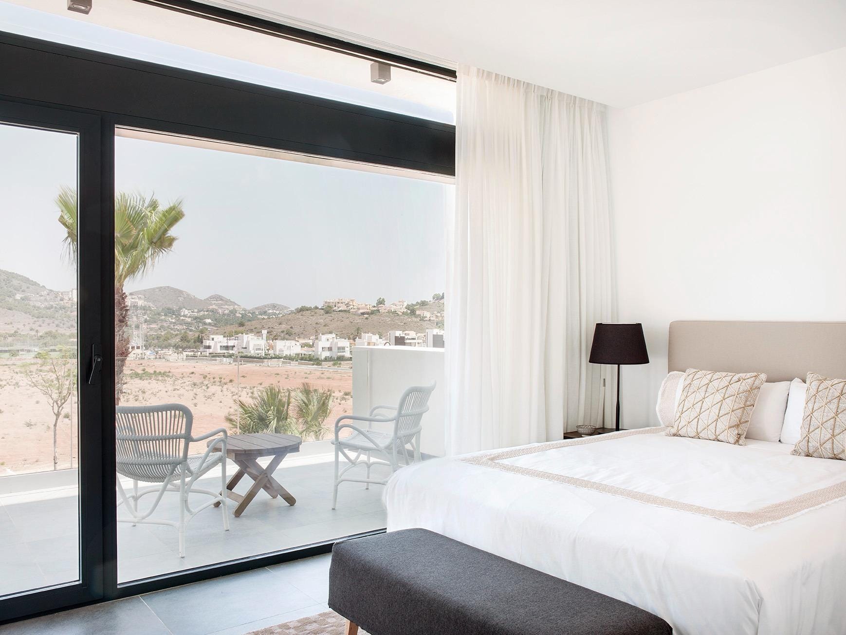New-Build-Villas-for-Sale-at-La-Manga-Club-–-Luxury-Living-in-a-Prestigious-Resort-15 Bedroom with floor-to-ceiling glass and a private terrace seating area in La Manga Club, Murcia