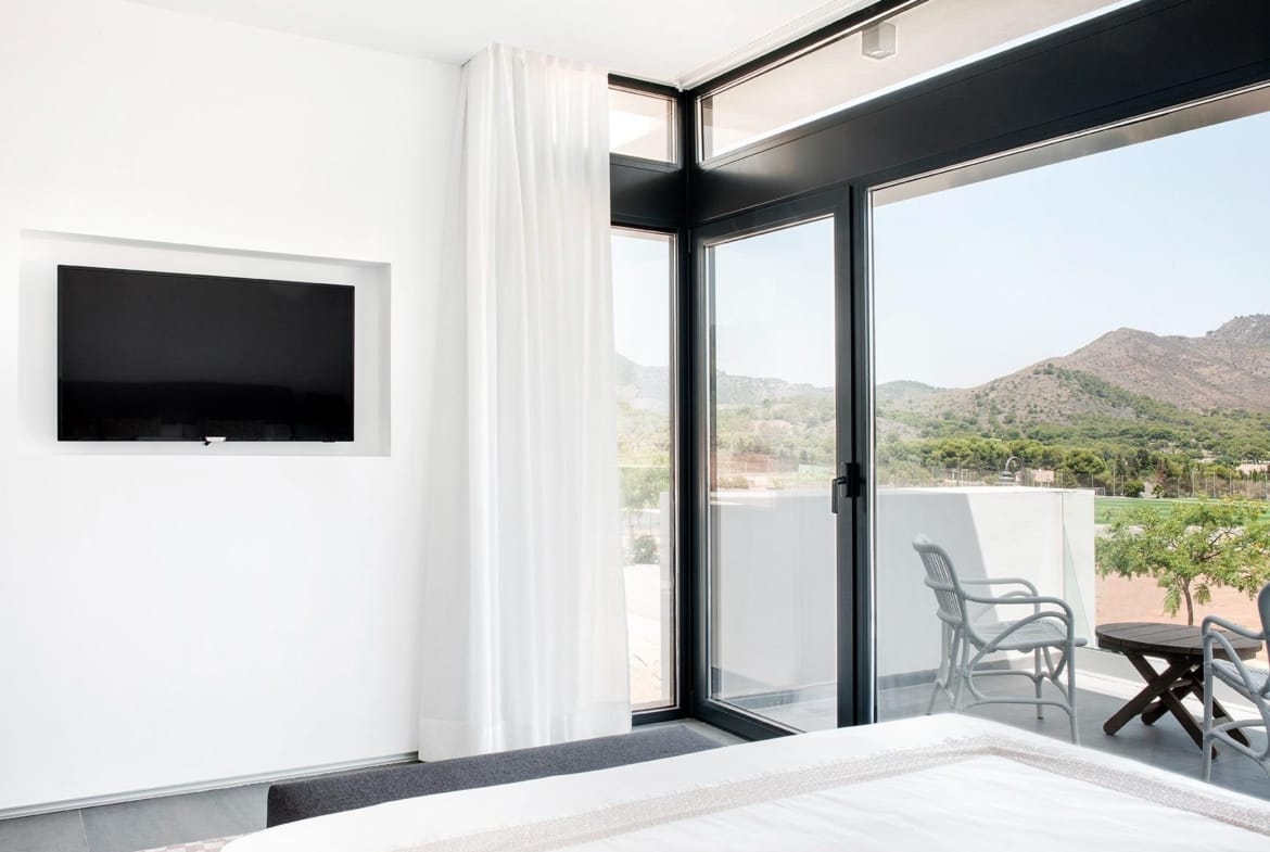 Bedroom with terrace access and wide hillside views in La Manga Club, Murcia