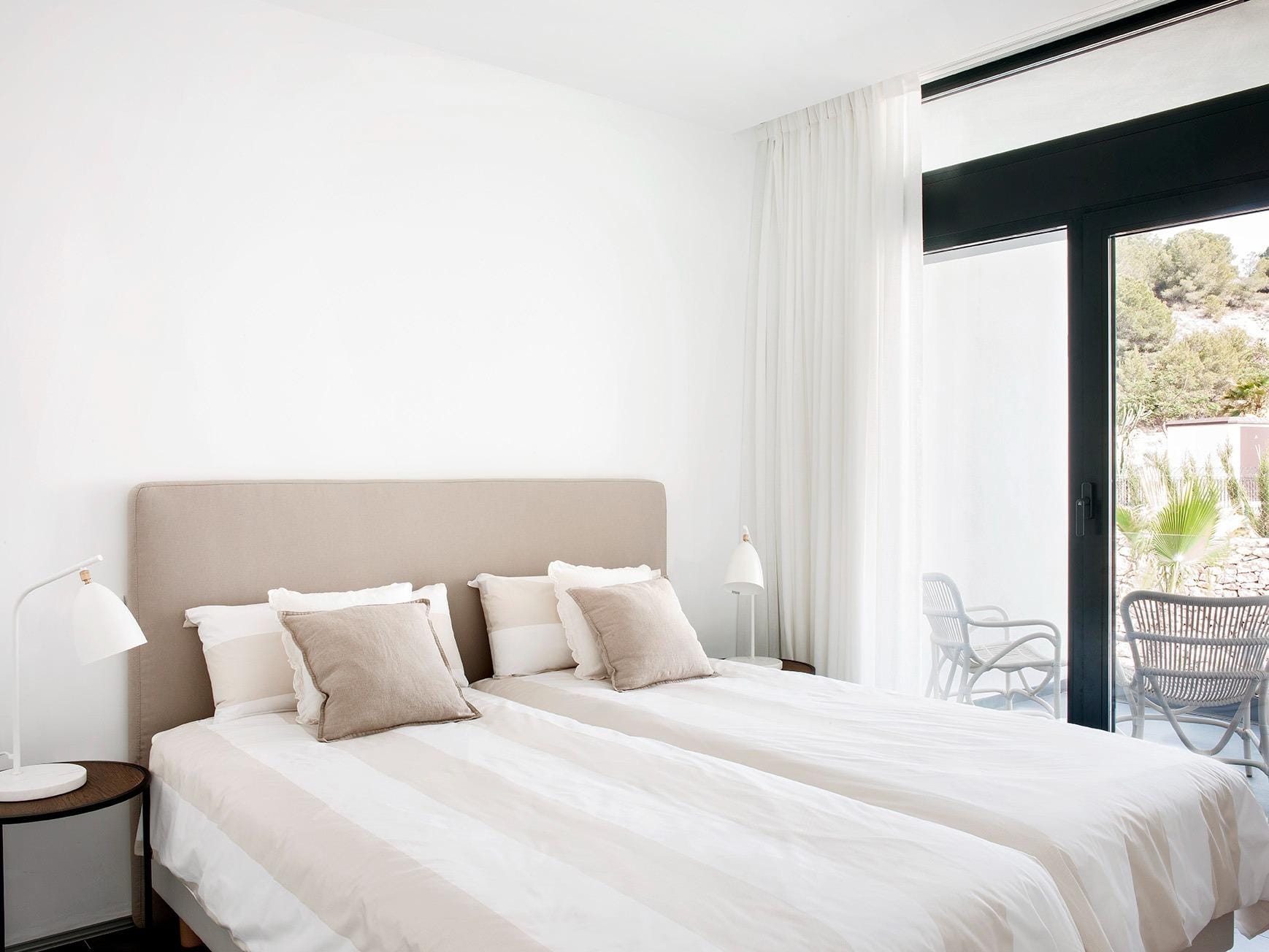 New-Build-Villas-for-Sale-at-La-Manga-Club-–-Luxury-Living-in-a-Prestigious-Resort-18 Twin bedroom with soft neutral decor and terrace access in La Manga Club, Murcia