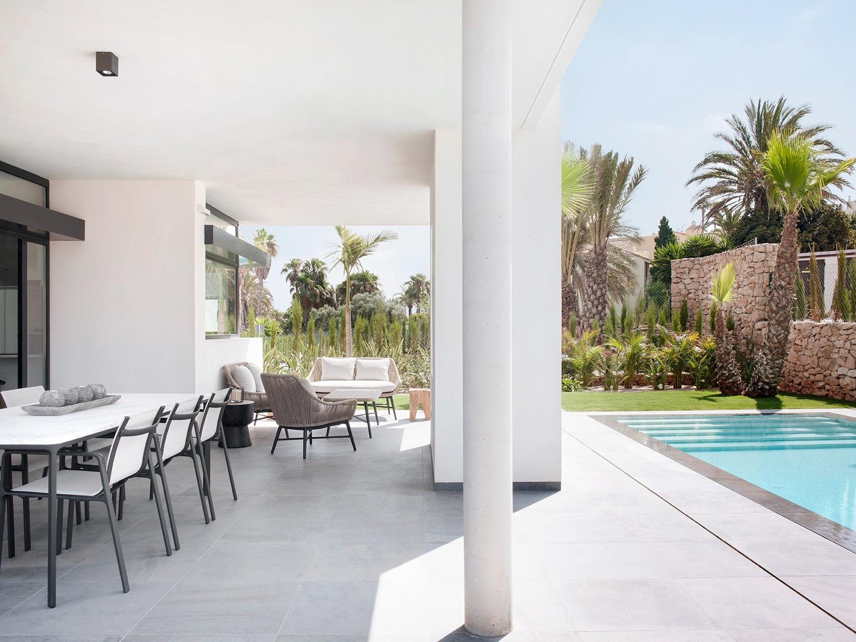 Covered terrace with outdoor dining, lounge seating and private pool in La Manga Club, Murcia