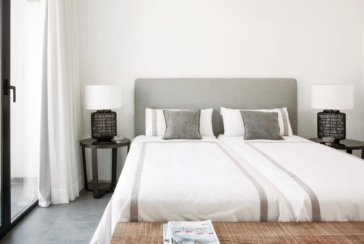 Twin bedroom with upholstered headboard and calm neutral styling in La Manga Club, Murcia