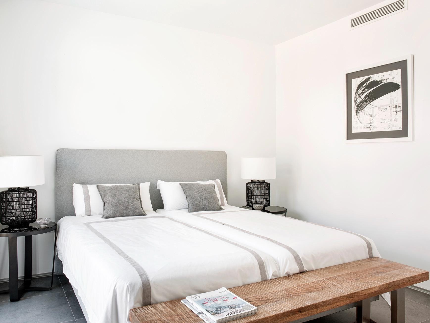New-Build-Villas-for-Sale-at-La-Manga-Club-–-Luxury-Living-in-a-Prestigious-Resort-22 Twin bedroom with bedside lamps and a woven bench in La Manga Club, Murcia