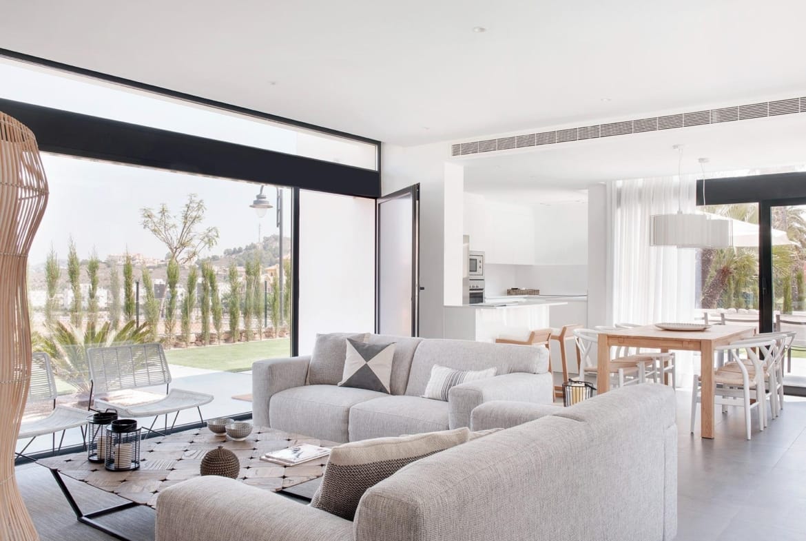Bright open-plan living and dining room with large glazing and white kitchen in La Manga Club, Murcia