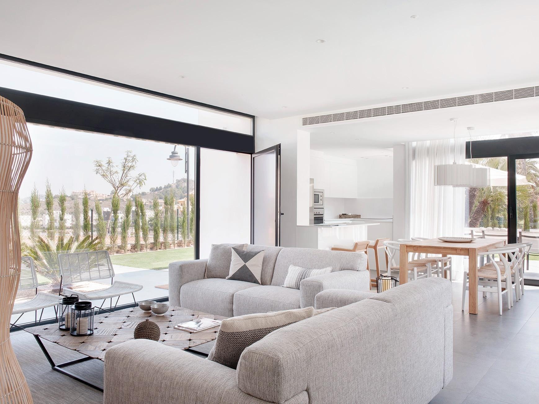 Bright open-plan living and dining room with large glazing and white kitchen in La Manga Club, Murcia