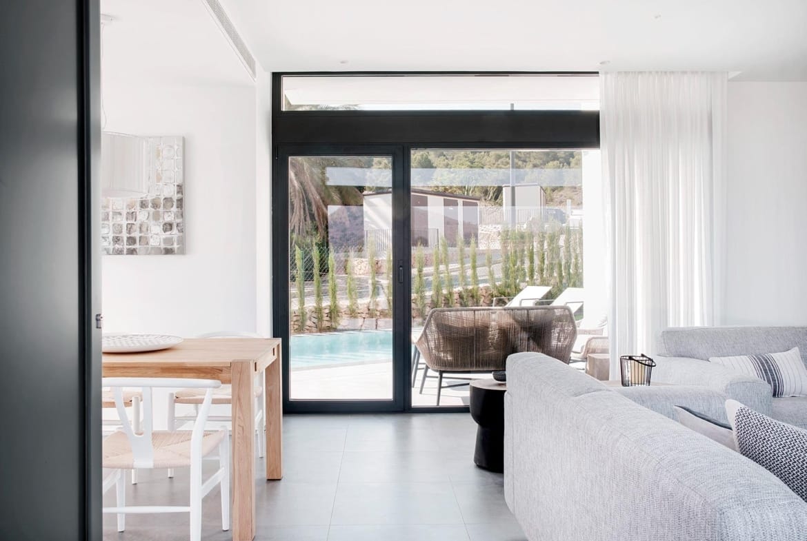 Living area with full-height glazed doors opening toward the pool terrace in La Manga Club, Murcia
