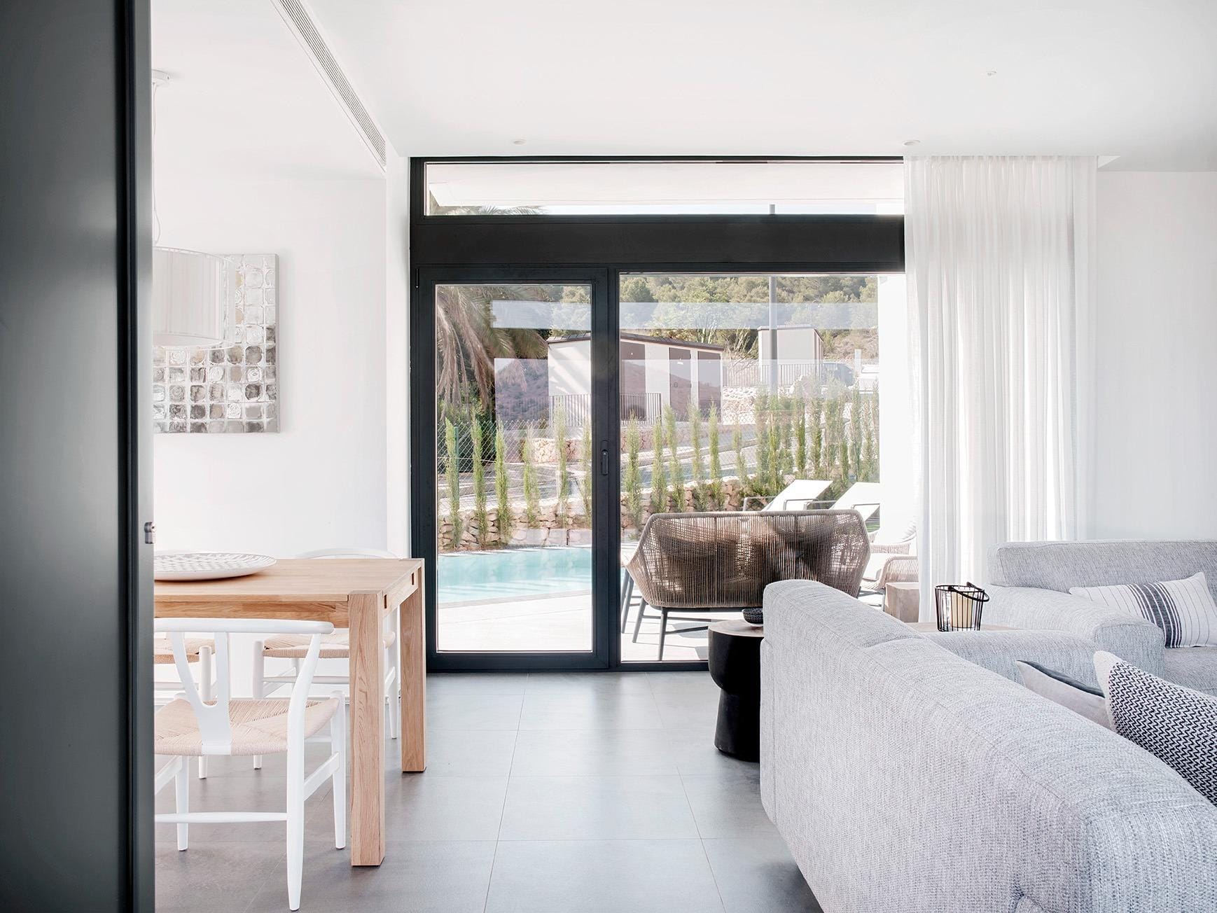 Living area with full-height glazed doors opening toward the pool terrace in La Manga Club, Murcia