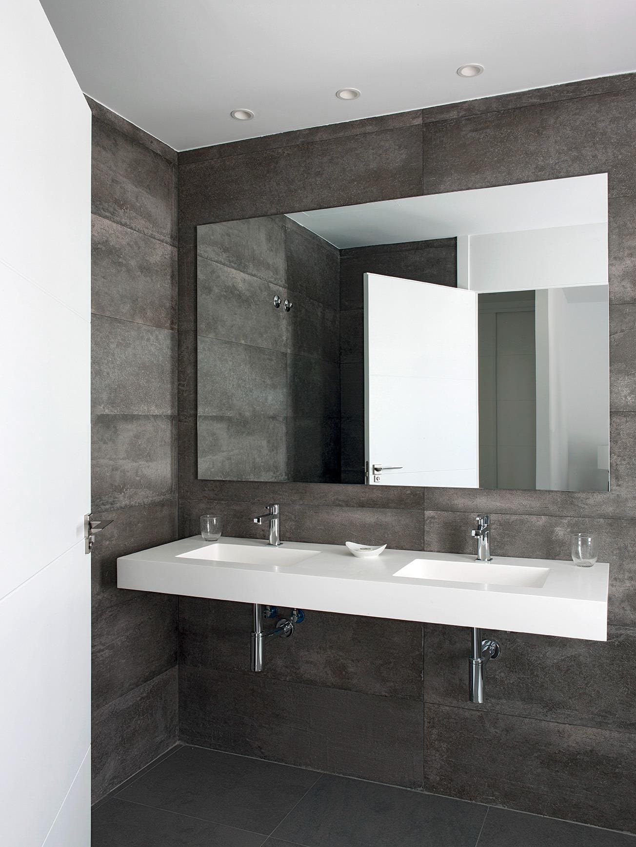 Contemporary bathroom with double vanity and dark stone-effect wall tiles in La Manga Club, Murcia