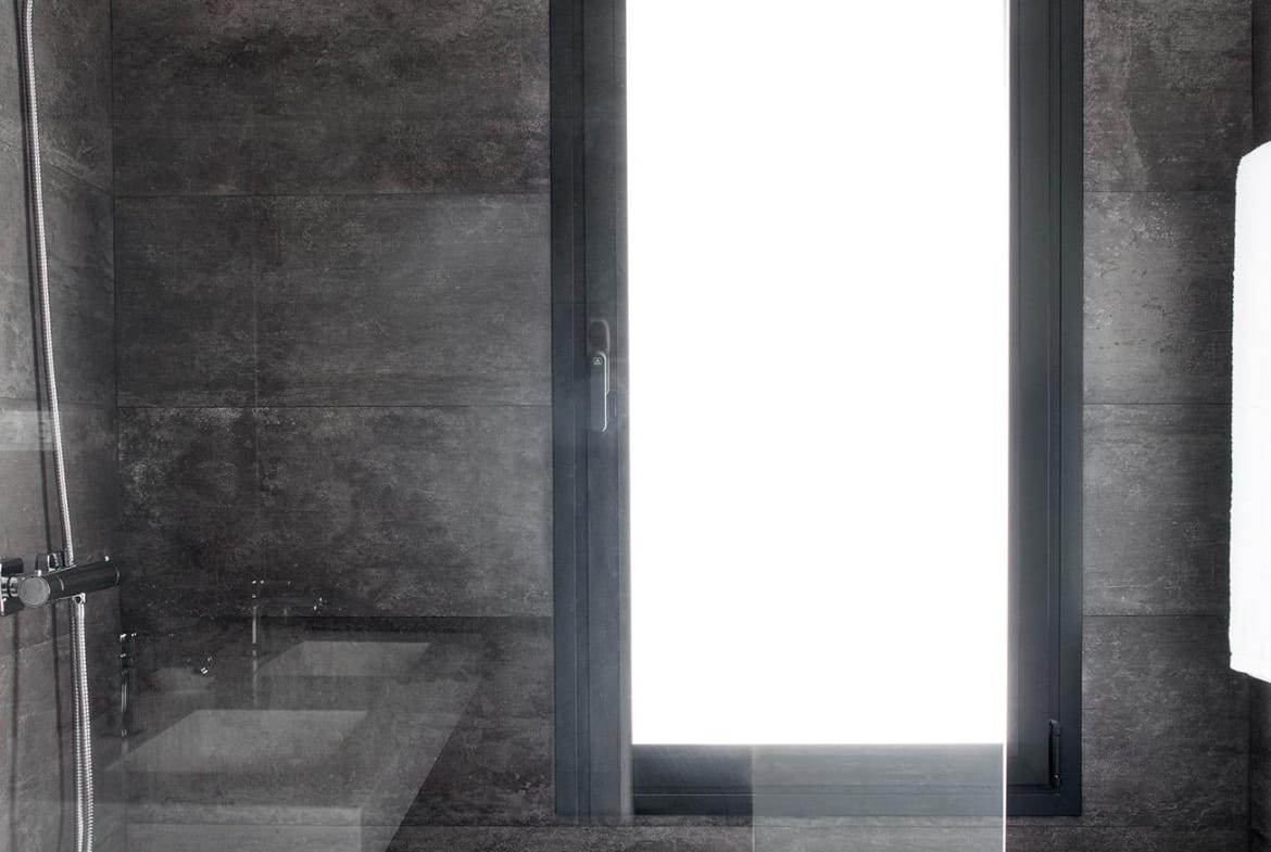 Walk-in shower with glass screen and tall frosted window in a villa in La Manga Club, Murcia
