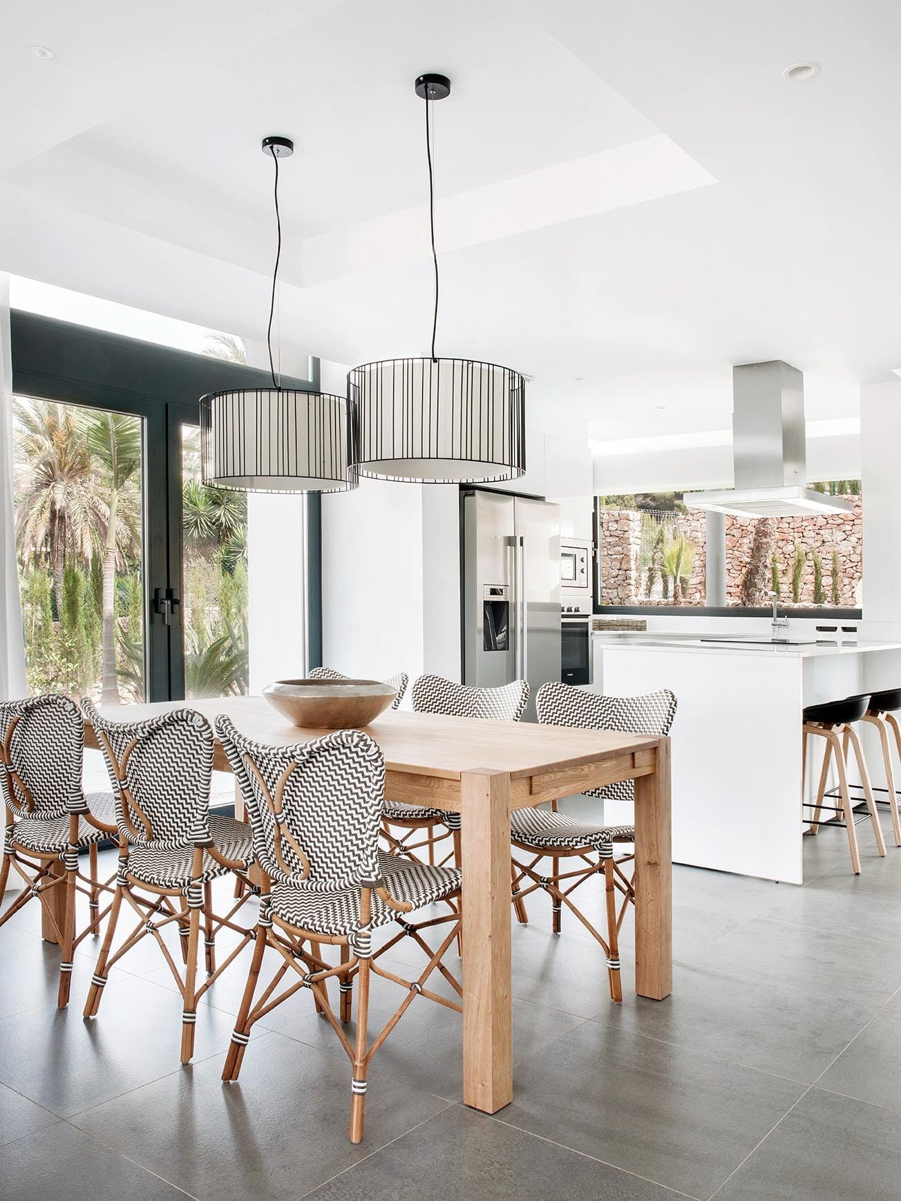 New-Build-Villas-for-Sale-at-La-Manga-Club-–-Luxury-Living-in-a-Prestigious-Resort-8 Dining area beside a minimalist white kitchen with island in La Manga Club, Murcia