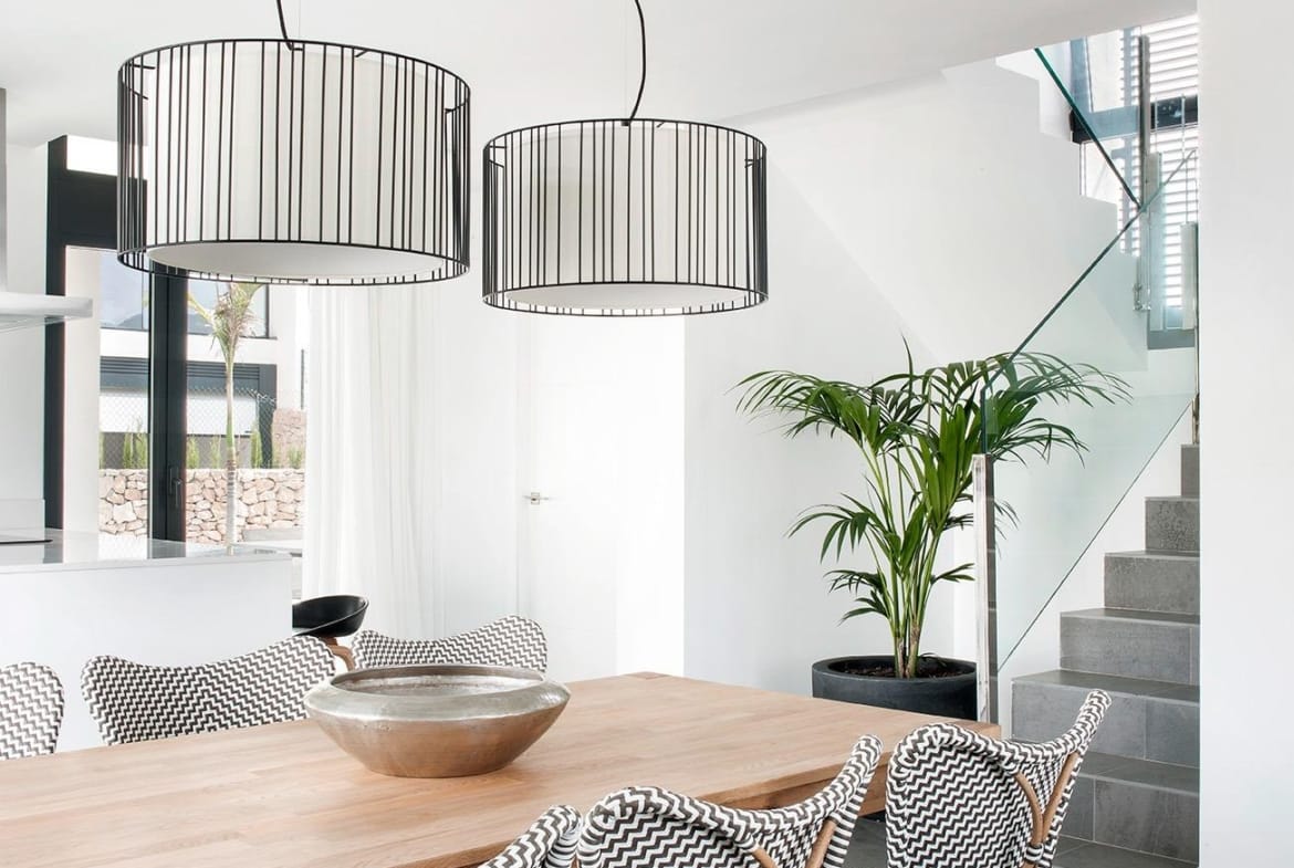 Dining space with statement lighting and glass-railed staircase in La Manga Club, Murcia