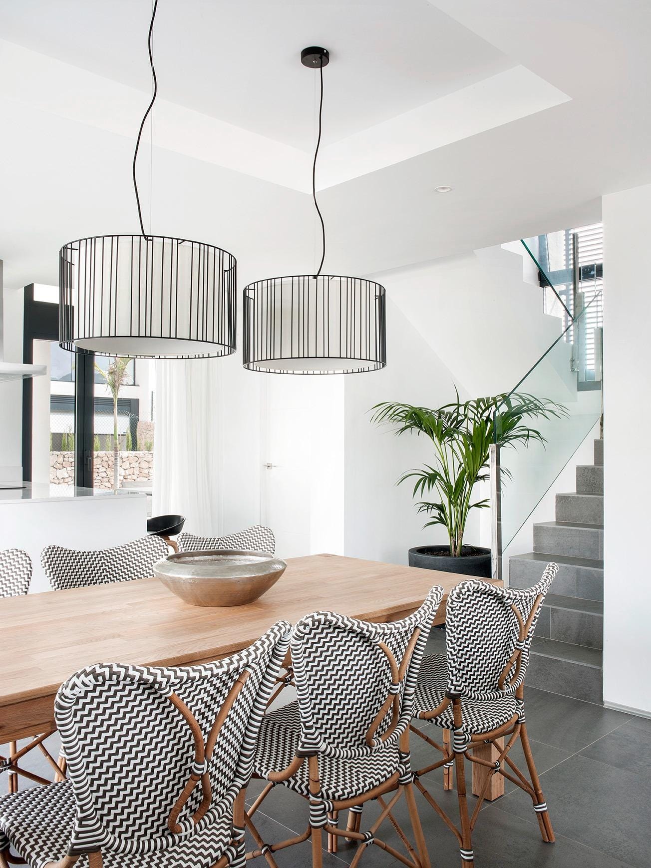 New-Build-Villas-for-Sale-at-La-Manga-Club-–-Luxury-Living-in-a-Prestigious-Resort-9 Dining space with statement lighting and glass-railed staircase in La Manga Club, Murcia