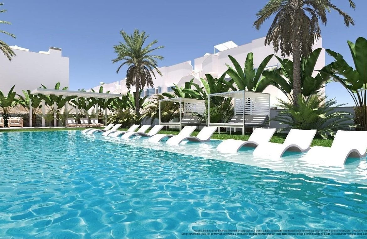 Communal swimming pool with submerged loungers and palm trees in Torre de la Horadada, Alicante