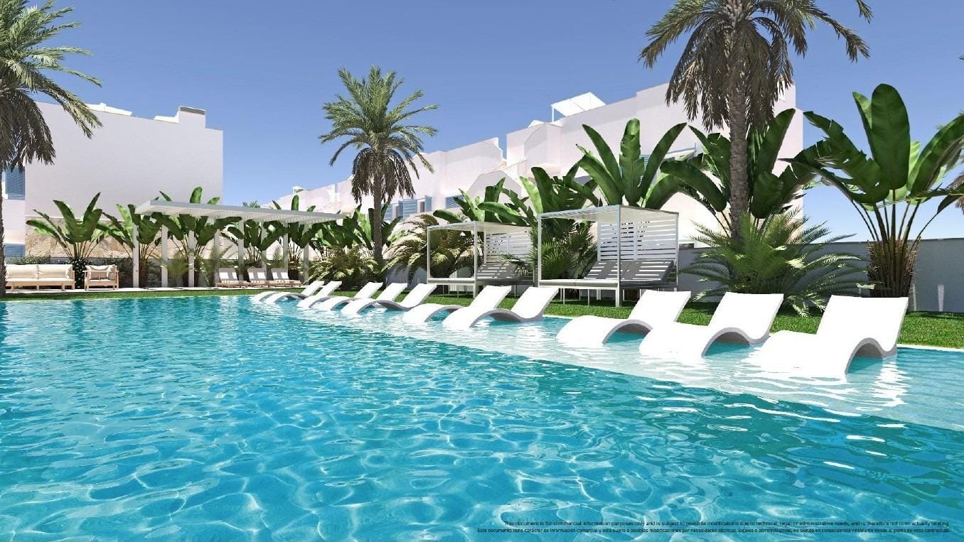 Communal swimming pool with submerged loungers and palm trees in Torre de la Horadada, Alicante
