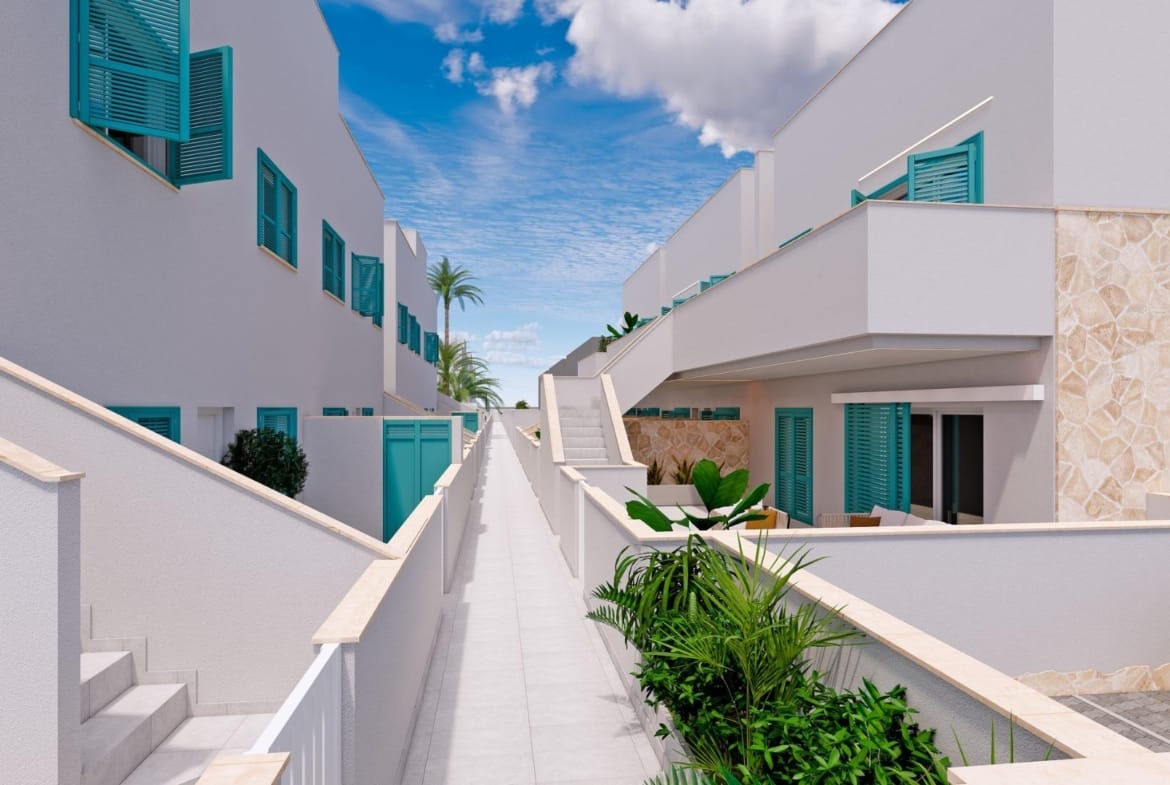 Walkway between white homes with turquoise shutters and terraces in Torre de la Horadada, Alicante