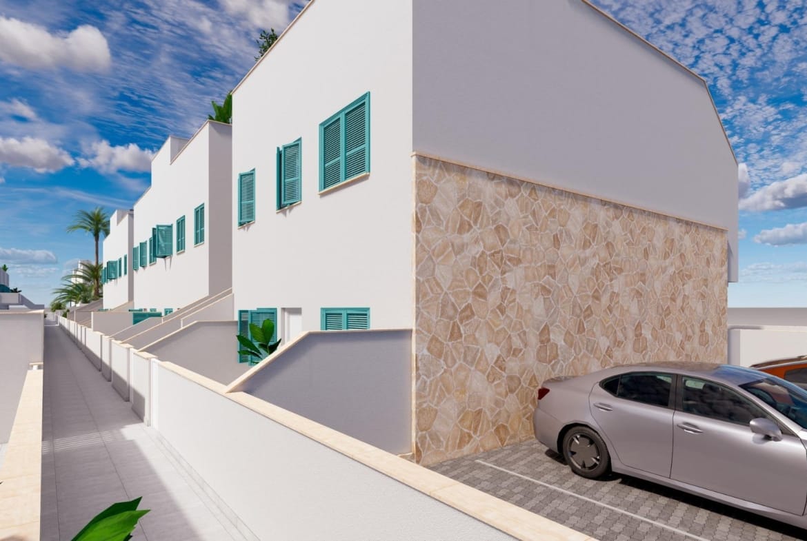 White residential building with stone cladding and a parking area in Torre de la Horadada, Alicante